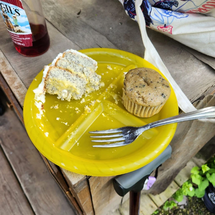 A yellow plate with cake and a muffin, a soda in the background.