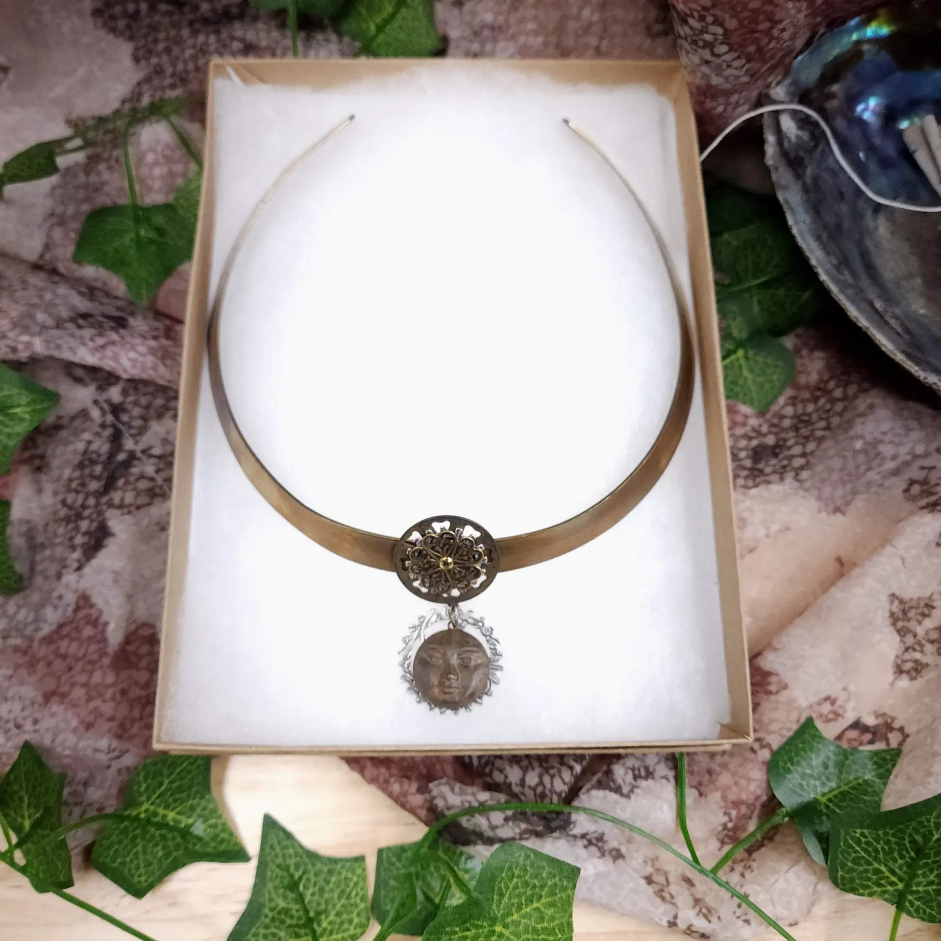 NoMonet Brass Torc – Filigree Flower & Sun Face Charm